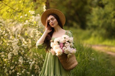 Parkta şakayık demeti olan güzel bir kadın.