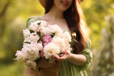 Parkta şakayık demeti olan güzel bir kadın, yakın plan.