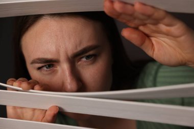 Paranoya işte. Endişeli kadın pencereden içeri bakıyor.