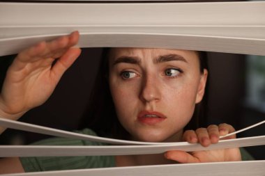 Paranoya işte. Endişeli kadın pencereden içeri bakıyor.