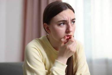 Evde paranoyadan muzdarip korkmuş bir kadın.