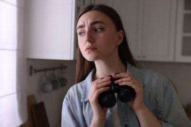 Paranoya işte. Mutfakta dürbünü olan endişeli kadın, mesaj için yer var.