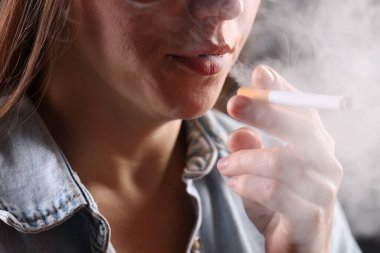 Gömlekli kadın sigara içiyor, yakın plan. Kötü alışkanlık.