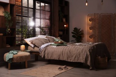 Yatak odasında güzel çarşafları olan rahat bir yatak.