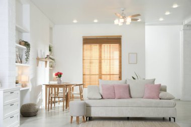 Odada rahat bir kanepe ve sandalyeli şık bir yemek masası. İç tasarım