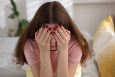 Evdeki yatakta üzgün genç kız.