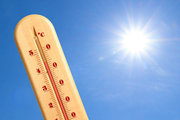 Чрезвычайно высокая температура на термометре против голубого неба в солнечный день. Летняя погода