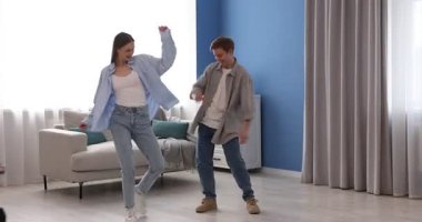 Mutlu genç çift evde dans ediyor.