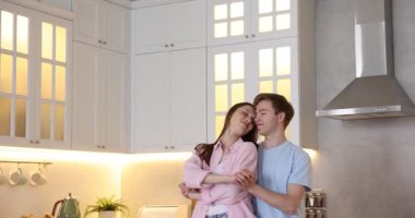 Genç çift mutfakta dans ediyor, kamera aşağı iniyor.