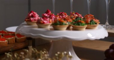 Şef açık büfe için kırmızı havyarlı sandviç yapıyor. Kapalı masa, yakın çekim. Kamera sola hareket ediyor