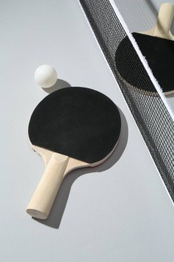 Ping pong raketleri, arka planda top ve ağ