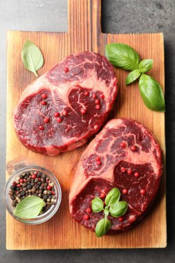 Gri masa üzerinde çiğ et ve baharat parçaları.