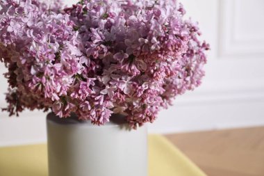 İçerideki masada vazoda güzel leylak çiçekleri, yakın plan.