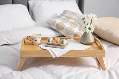 Nefis bir kahvaltı tepsisi ve çiçeklerle kapalı bir yerde, yakın plan.