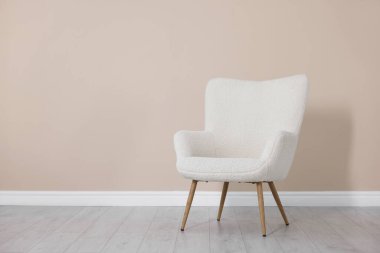 Bej duvarın yanındaki rahat koltuk, metin için boşluk.