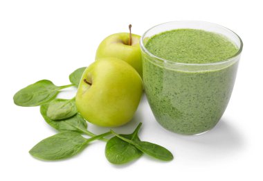 Lezzetli ıspanaklı smoothie ve beyaz üzerine izole edilmiş malzemeler.