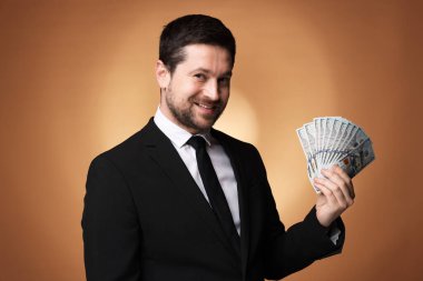 Altın arka planda dolar banknotları olan mutlu açgözlü bankacı.