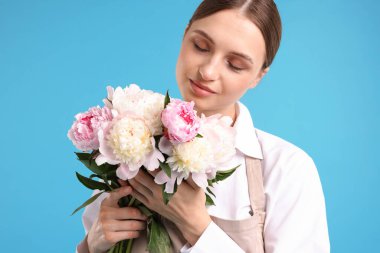 Açık mavi arka planda güzel şakayık demeti olan bir çiçekçi.