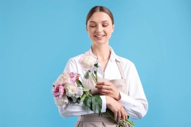 Açık mavi arka planda güzel şakayık demeti olan bir çiçekçi.