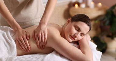 Spa salonunda kadın sırt masajı yaptırıyor.