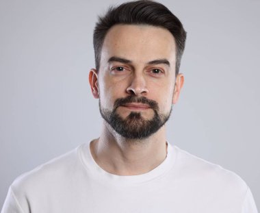 Gri arka planda yakışıklı bir adamın portresi, yakın plan.