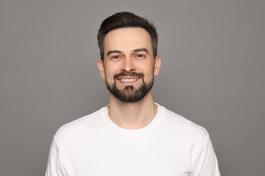 Gri arka planda tıraş olmadan önce gülümseyen adam