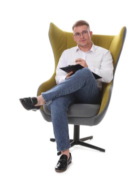 Gözlüklü bir psikolog, beyaz arka planda koltukta oturuyor.