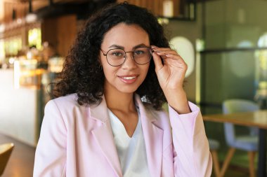 Kafedeki gülümseyen Latin Amerikalı kadının portresi.