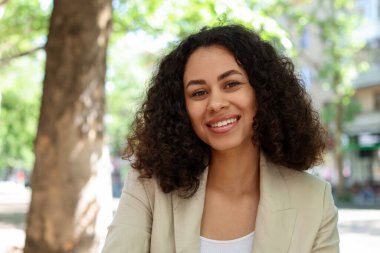 Açık havada gülümseyen Latin Amerikalı kadın portresi