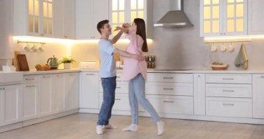 Mutfakta dans eden mutlu çift, sola hareket eden kamera.