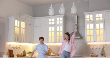 Mutfakta dans eden mutlu çift, kamera aşağı iniyor.