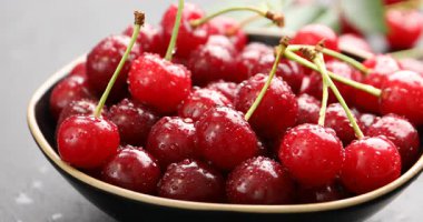 Masadan kirazını alan kadın, yakın plan.