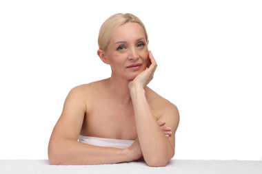 Beyaz arka planda havlusu olan güzel bir kadının portresi.