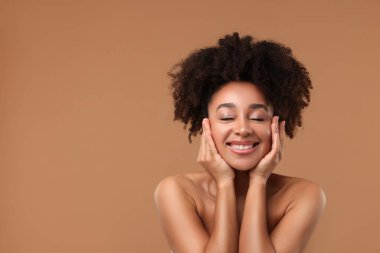 Açık kahverengi arka planda spa tedavisinden sonra güzel Brezilyalı bir kadının portresi. Metin için boşluk