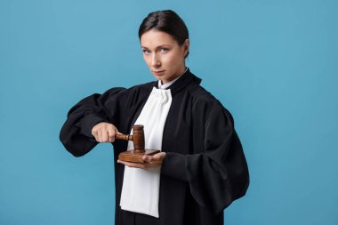 Açık mavi arkaplanda çekiç ve ses bloğuyla yargıla