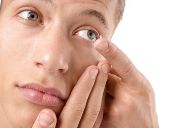 Beyaz arkaplana kontak lens takan adam, yakın plan