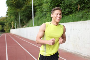 Stadyumda koşan sporcu adam, mesaj için yer var.