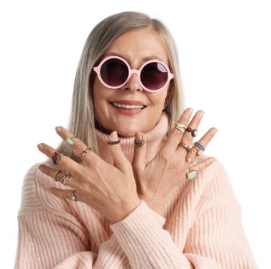 Üst düzey kadın beyaz arka planda farklı yüzükler takıyor.