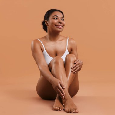 Bej arkaplan üzerindeki epilasyon işleminden sonra pürüzsüz ciltli kadın, metin için boşluk