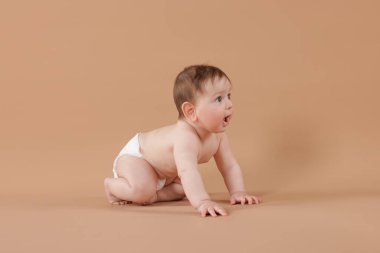 Bej arka planda emekleyen şirin bir bebek.