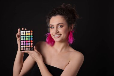 Siyah arka planda parlak göz falı olan gülümseyen kadın.