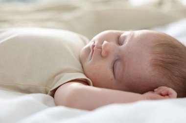 Yeni doğmuş şirin bebek evde yatakta uyuyor.