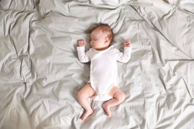 Sevimli yeni doğmuş bebek yatakta uyuyor.