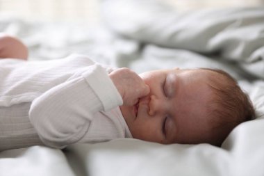 Sevimli yeni doğmuş bebek yatakta uyuyor, yakın plan.