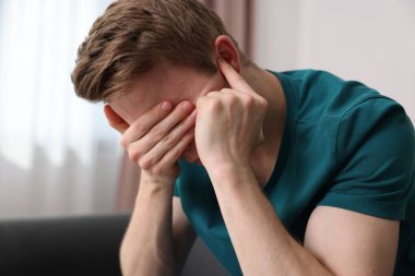 Evde paranoyadan muzdarip korkmuş bir adam.