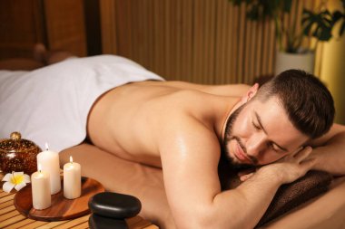 Güzellik salonunda masaj masasında yatan yakışıklı adam.