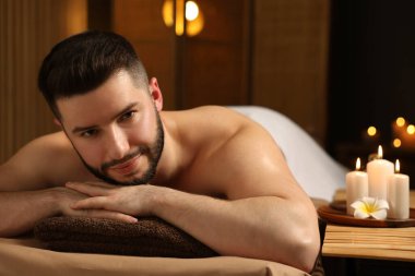 Güzellik salonunda masaj masasında yatan yakışıklı adam.