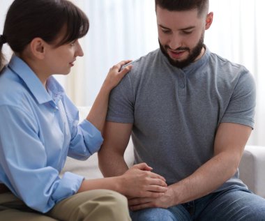 Ofisteki koltukta terapi seansında hastaya destek veren psikolog.