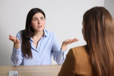 Genç bir kadın iş kadınına şikayet ediyor.