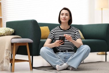 Evde modern akıllı telefon kullanan bir kadın.